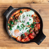 Free photo closeup of traditional shakshuka in a frying pan on a wooden background